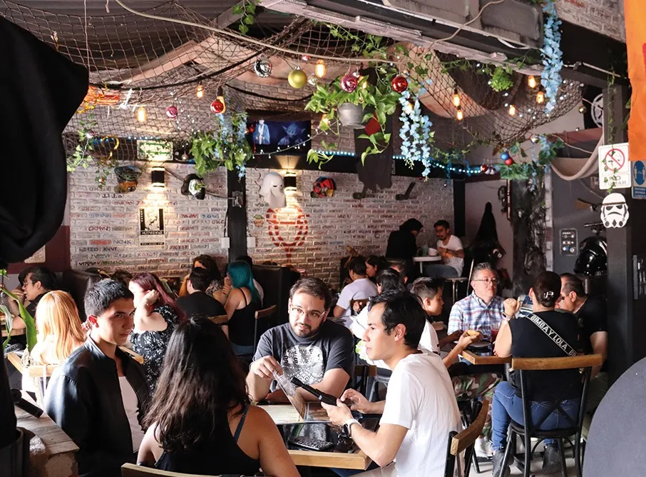 El salón lleno, con redes, plantas y luces colgantes
