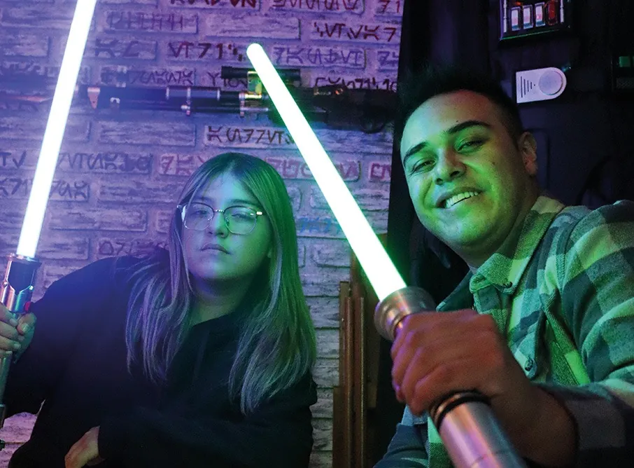 Pareja con sables de luz bajo luces de neón