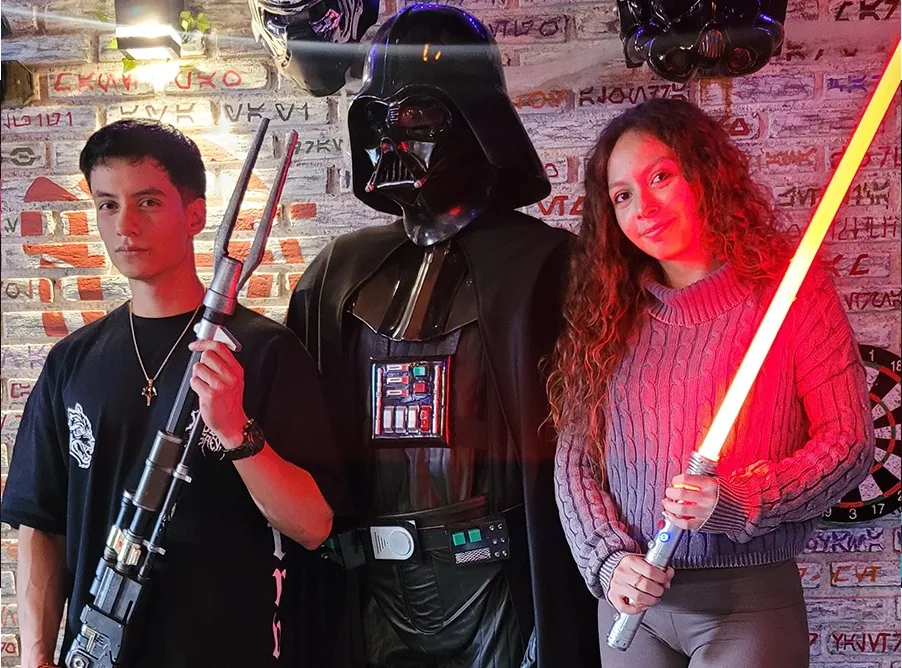 Dos jóvenes con Darth Vader y un sable rojo